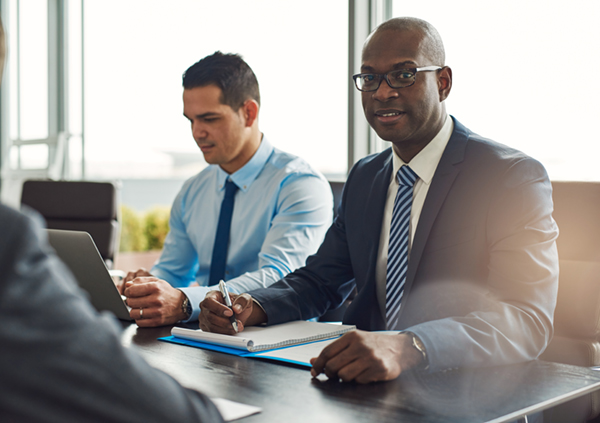 A businessman seated at a conference table with colleagues