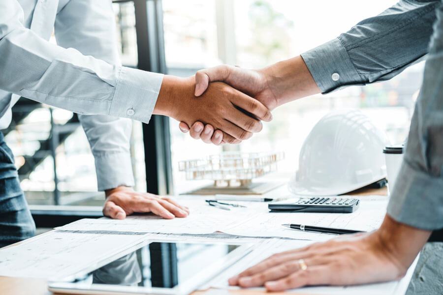 Close up of two people shaking heads over table with business documents