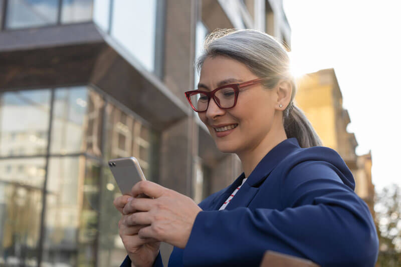 Businesswoman smiling and reading email on mobile phone